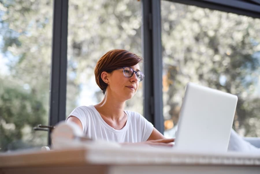 Personne alternant entre ses notes et un travail sur ordinateur